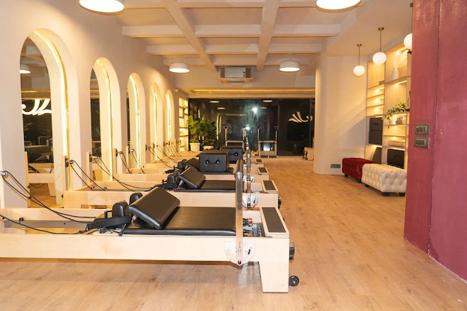 Wooden Pilates reformers and arched mirrors at J Pilates Sanpada