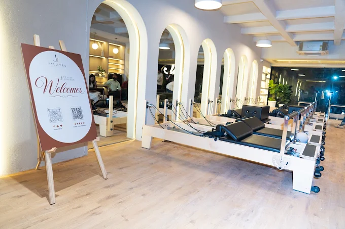 Welcome sign beside reformers at J Pilates Sanpada